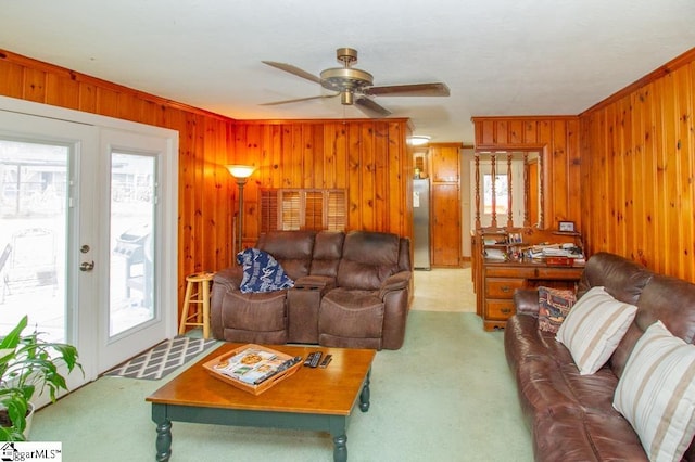 carpeted living room featuring a healthy amount of sunlight and wood walls