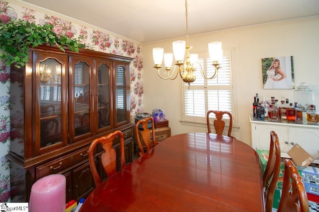 dining area with ornamental molding and a notable chandelier