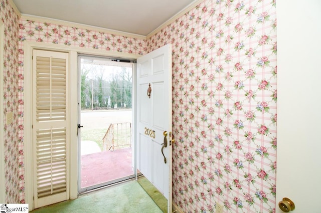 entryway featuring ornamental molding, light colored carpet, and wallpapered walls