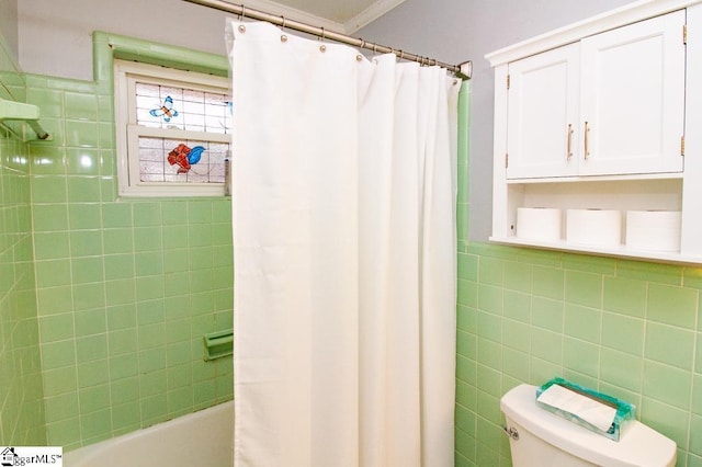 bathroom with toilet, shower / tub combo, and tile walls