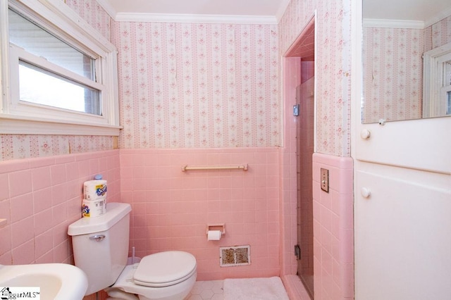 bathroom with wallpapered walls, visible vents, ornamental molding, and wainscoting