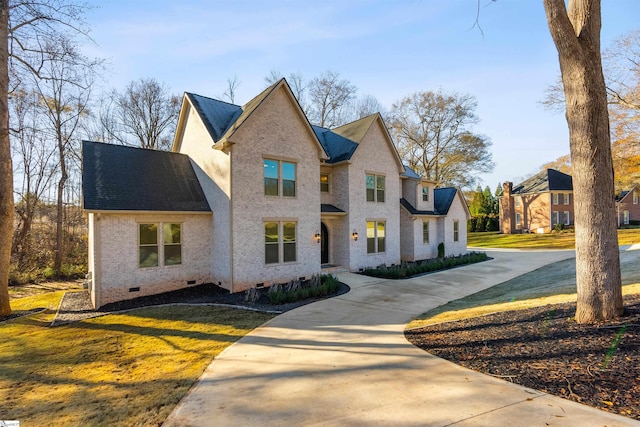 view of front facade with roof with shingles, a front lawn, crawl space, and brick siding