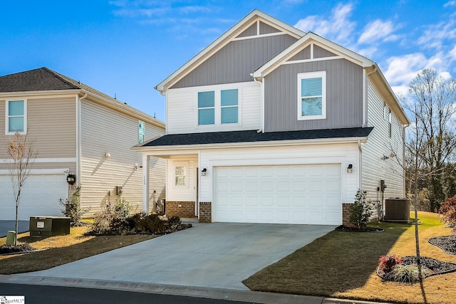 view of front of property featuring central AC unit, a garage, brick siding, driveway, and board and batten siding