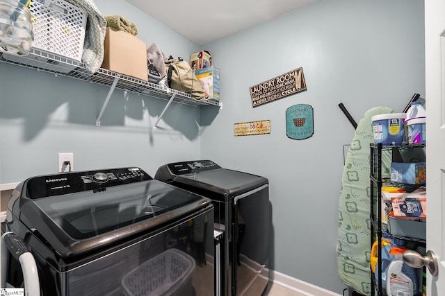 washroom with baseboards, laundry area, and washer and dryer