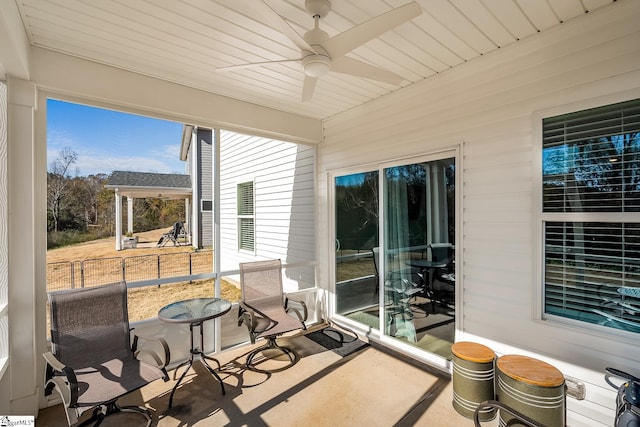 sunroom / solarium featuring a ceiling fan and wood ceiling