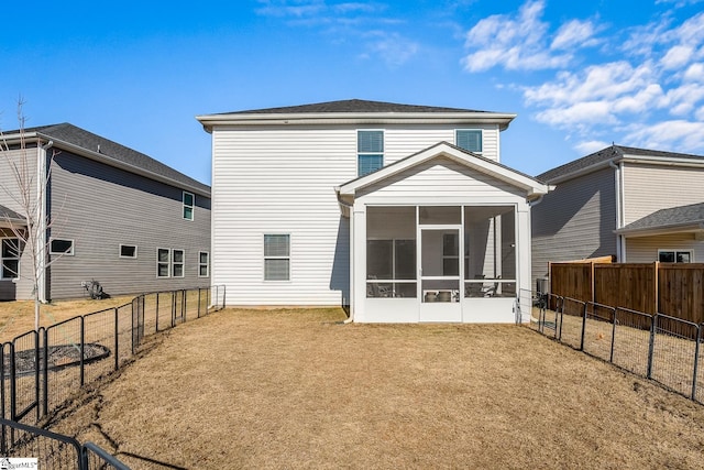 back of house featuring a sunroom, a fenced backyard, and a yard