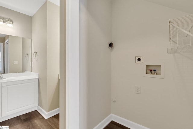 washroom featuring dark wood-type flooring, washer hookup, a sink, and electric dryer hookup