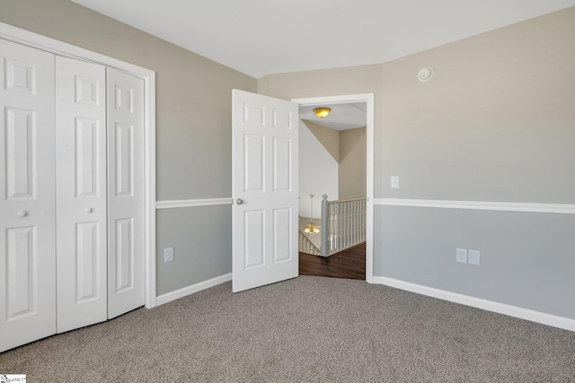 unfurnished bedroom featuring a closet, carpet flooring, and baseboards