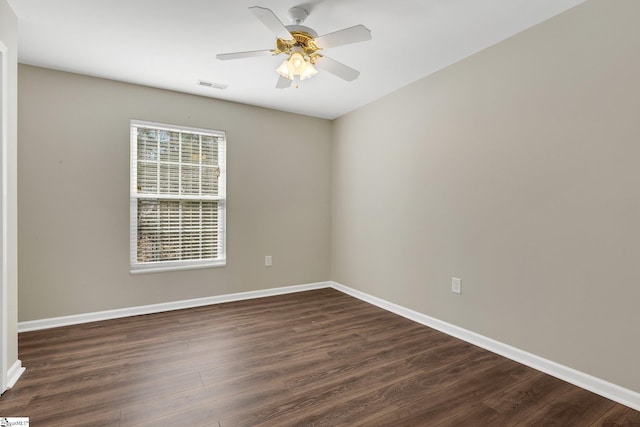 spare room with baseboards, visible vents, ceiling fan, and dark wood-type flooring