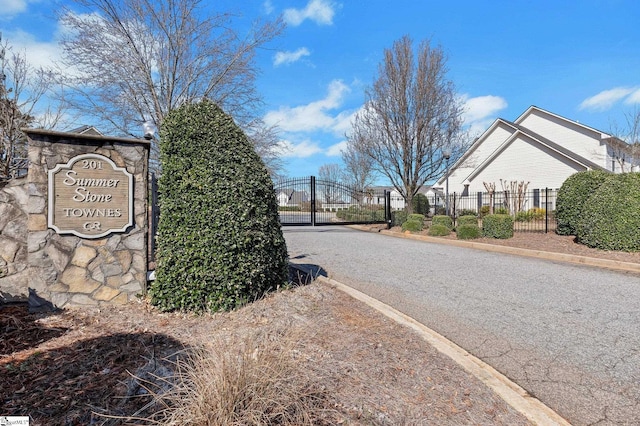 view of street with a gate, curbs, and a gated entry