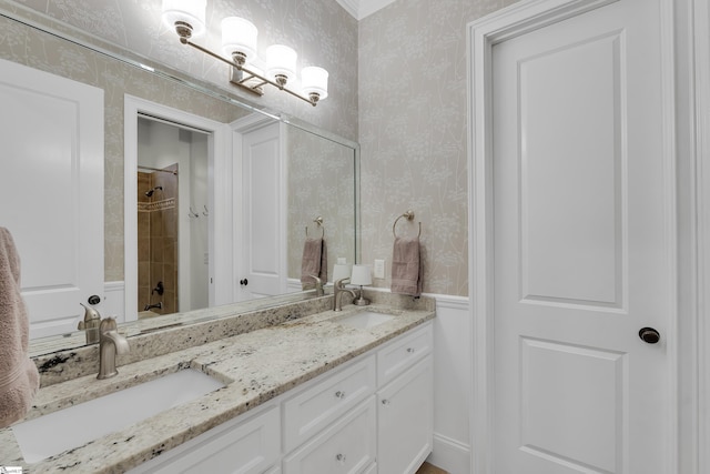 bathroom featuring double vanity, a sink, and wallpapered walls