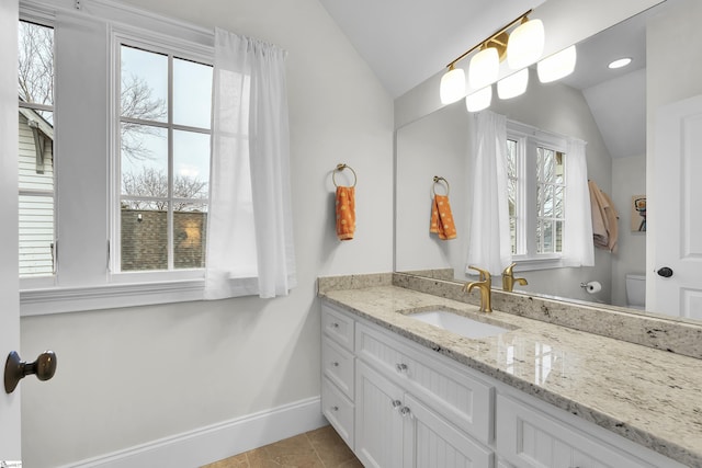 bathroom featuring vaulted ceiling, vanity, toilet, and baseboards