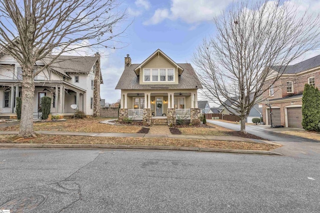 view of front of home featuring a porch, driveway, a chimney, and a garage