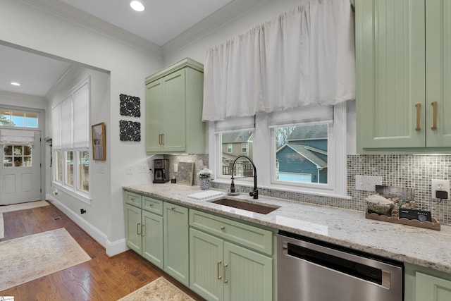 kitchen with dark wood finished floors, green cabinets, ornamental molding, a sink, and dishwasher