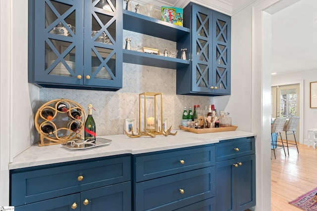 bar featuring a dry bar, decorative backsplash, and wood finished floors