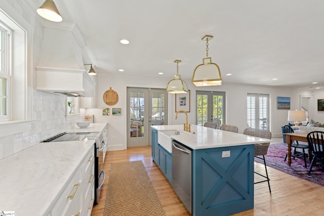 kitchen with french doors, blue cabinetry, stainless steel appliances, white cabinetry, and a sink