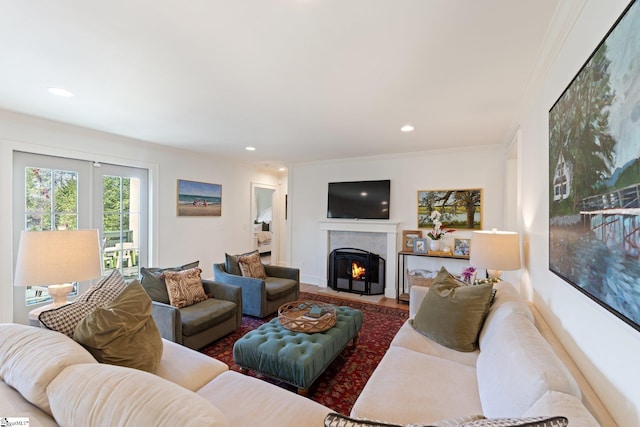 living area with a fireplace with flush hearth, recessed lighting, and ornamental molding