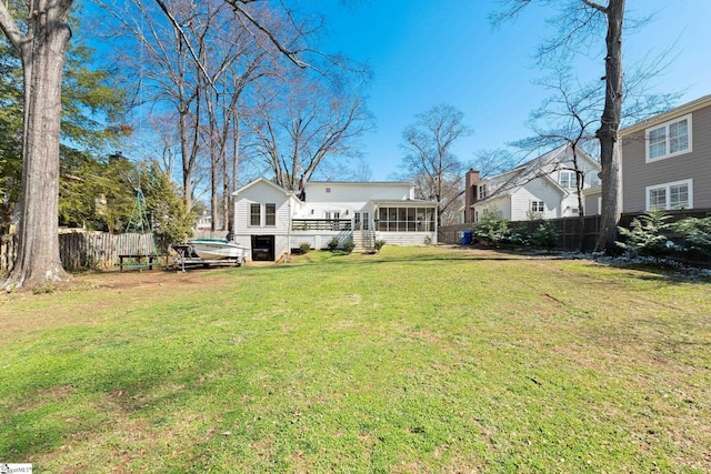 back of house with a sunroom, fence, and a yard