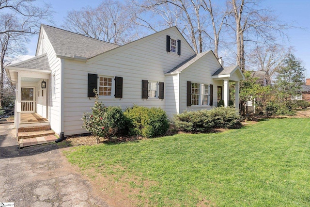 view of home's exterior featuring roof with shingles and a yard