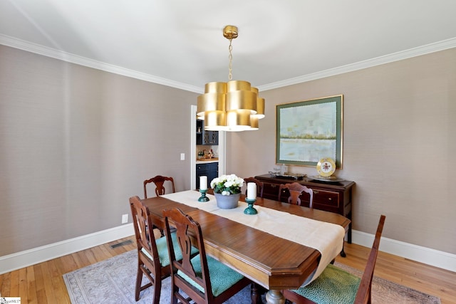 dining area featuring ornamental molding, visible vents, baseboards, and wood finished floors