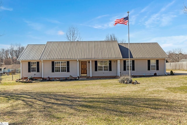 view of front of property featuring fence, a front lawn, and metal roof