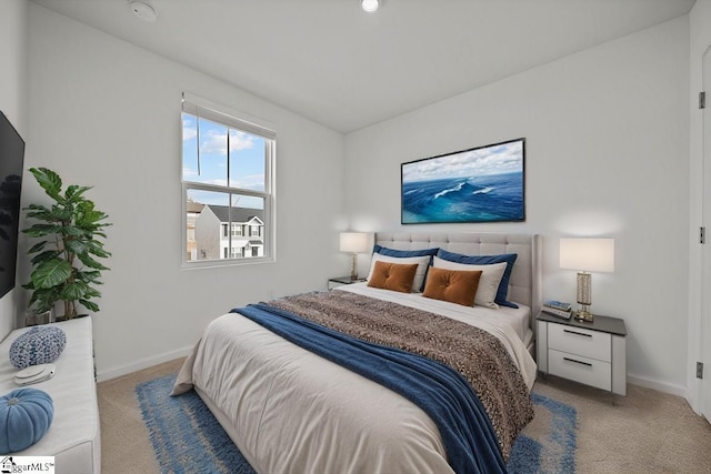 bedroom with light carpet and baseboards