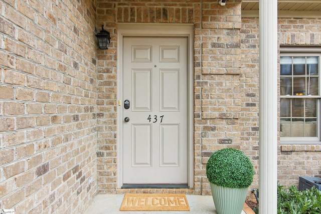 doorway to property with brick siding