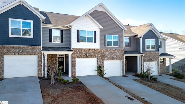 view of front of home featuring a garage, driveway, brick siding, and roof with shingles