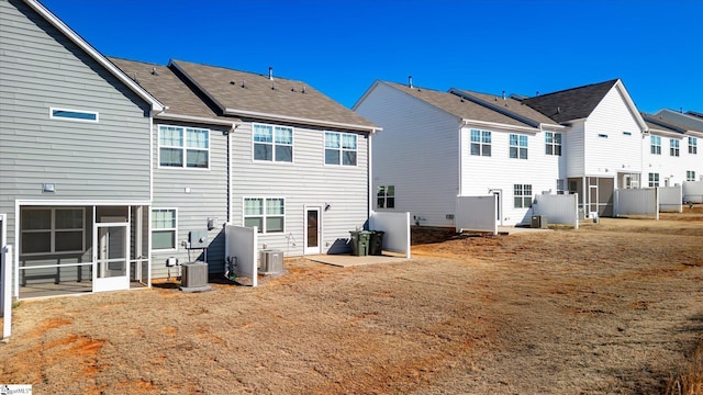 rear view of property with a residential view, a sunroom, and central AC