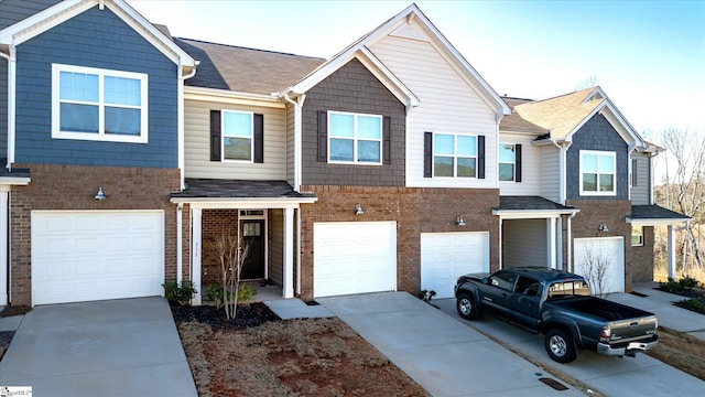 townhome / multi-family property with driveway, brick siding, and an attached garage