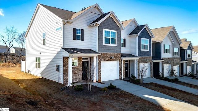 townhome / multi-family property featuring a garage, a residential view, concrete driveway, and brick siding