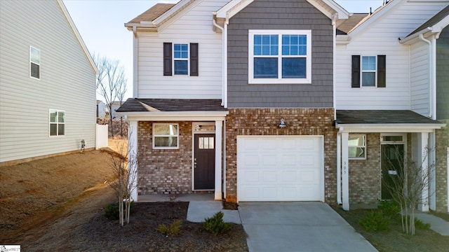 view of front of house featuring a garage, concrete driveway, and brick siding