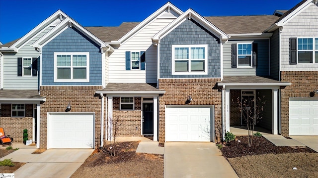 townhome / multi-family property featuring concrete driveway, brick siding, and an attached garage