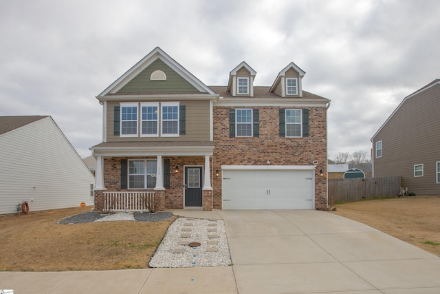 craftsman house featuring a porch, an attached garage, brick siding, fence, and driveway