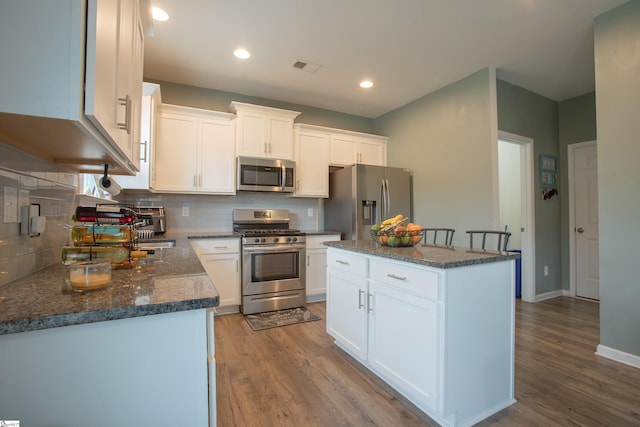 128 Lake Grove Rd, Simpsonville, SC 29681 - kitchen featuring light wood finished floors, visible vents, appliances with stainless steel finishes, white cabinetry, and a kitchen island