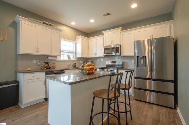 128 Lake Grove Rd, Simpsonville, SC 29681 - kitchen featuring visible vents, appliances with stainless steel finishes, dark wood-type flooring, white cabinets, and a kitchen island