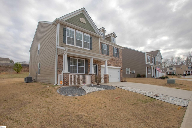 view of front of home featuring concrete driveway, an attached garage, covered porch, a front lawn, and brick siding