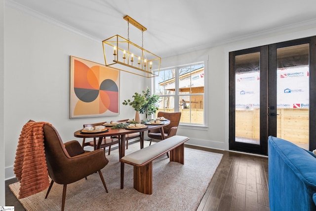 dining area featuring baseboards, dark wood-style floors, ornamental molding, french doors, and a notable chandelier