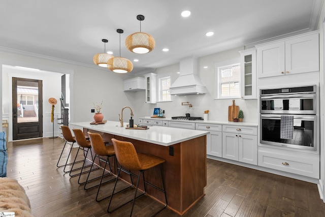 kitchen with custom range hood, glass insert cabinets, stainless steel appliances, and light countertops