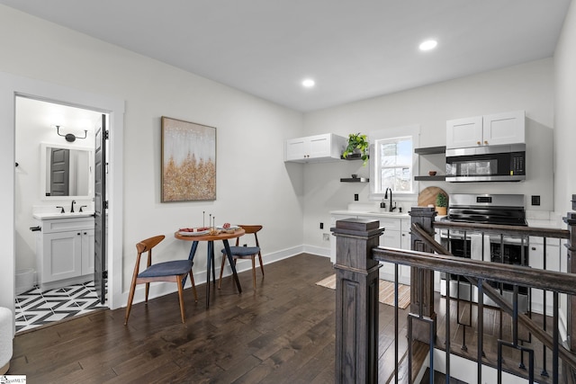 kitchen featuring open shelves, stainless steel appliances, light countertops, white cabinets, and a sink