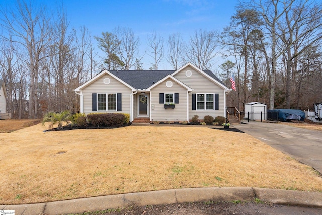 view of front of home with a front lawn, an outdoor structure, driveway, and a storage shed