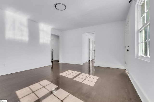 unfurnished room featuring dark wood-style floors and baseboards