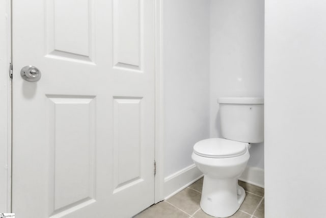 bathroom featuring tile patterned flooring, toilet, and baseboards