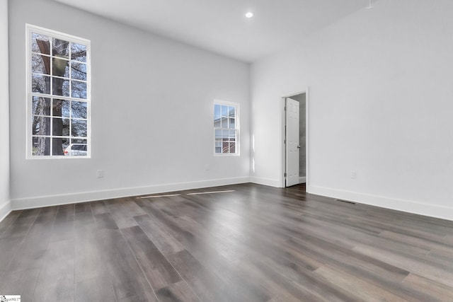 spare room featuring recessed lighting, dark wood finished floors, visible vents, and baseboards