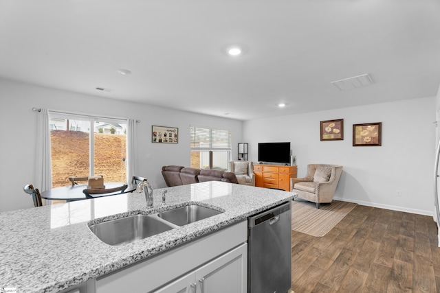 kitchen with a sink, visible vents, dark wood-style floors, light stone countertops, and dishwasher