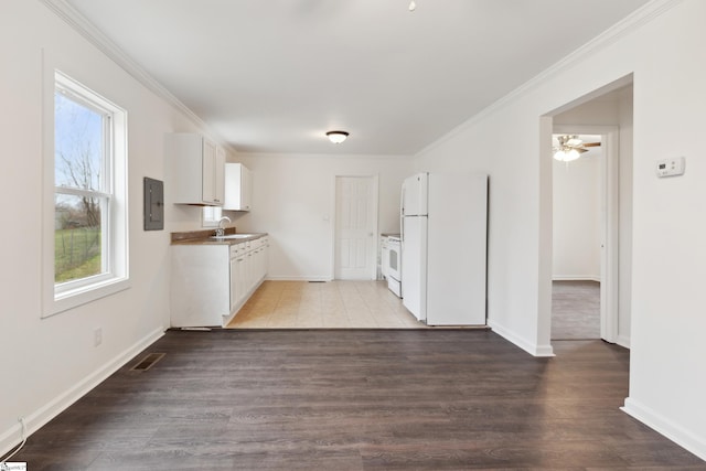 kitchen featuring crown molding, white cabinets, a sink, white appliances, and electric panel