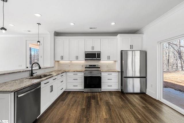 kitchen with stainless steel appliances, white cabinets, decorative light fixtures, and light stone countertops