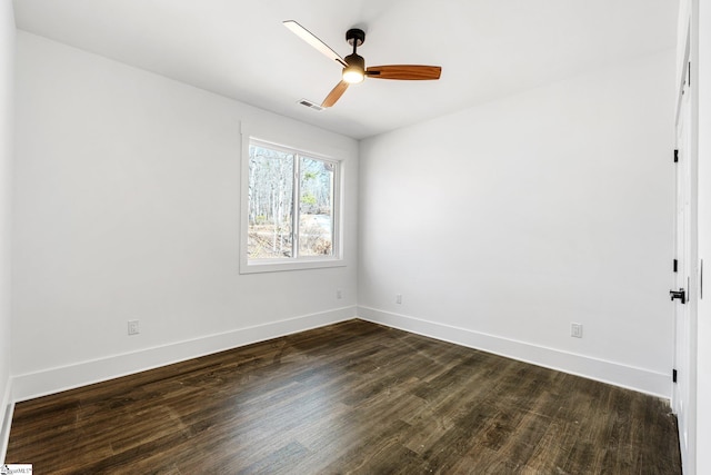 empty room with dark wood-style flooring, visible vents, ceiling fan, and baseboards