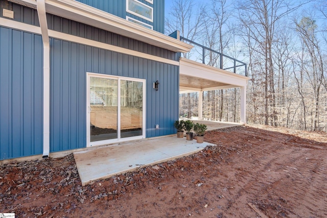 entrance to property with board and batten siding and a patio area