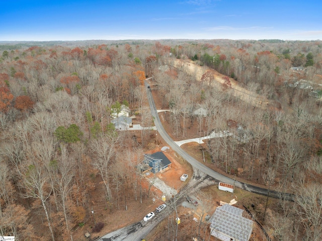 drone / aerial view with a wooded view